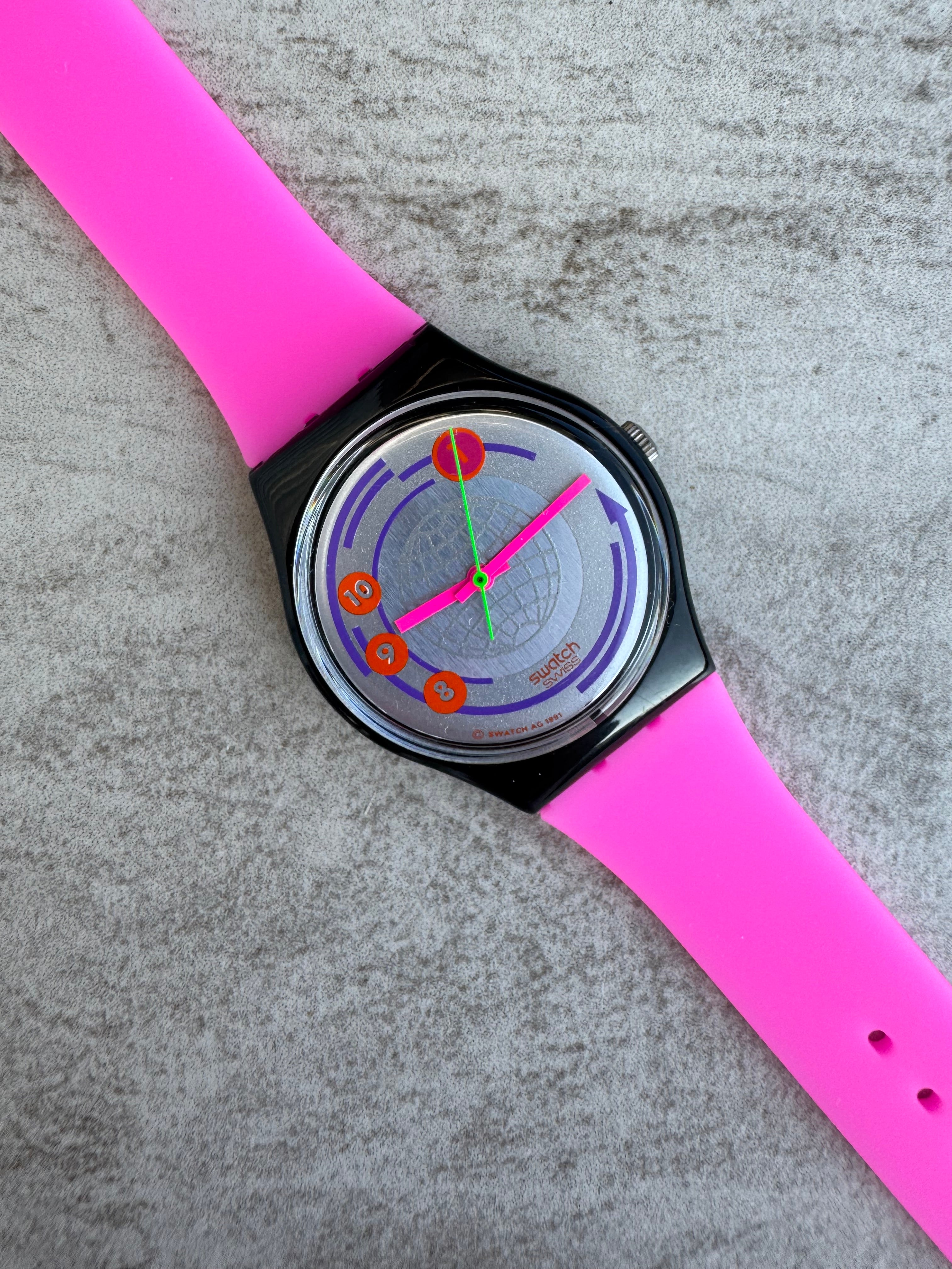 Swatch with a pink strap on a gray textured surface